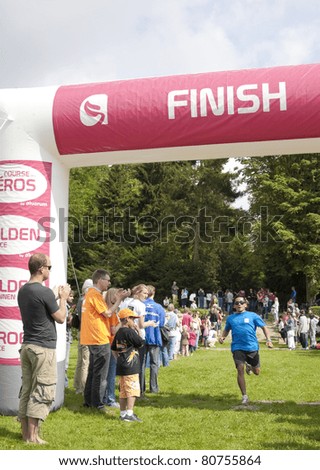 AMSTERDAM - JULY 10: Unidentified participant crosses the finish line in the Helden Race, Dutch division of the European Heroes Race, 6 km long charity run, July 10, 2011 in Amsterdam, The Netherlands