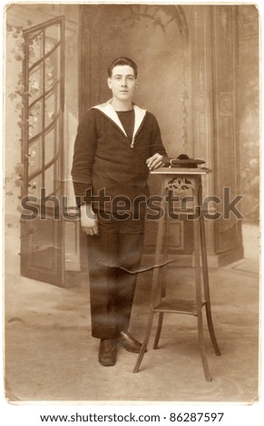 FRANCE - CIRCA 1920: Antique postcard depicting a French sailor in navy uniform, isolated on white background, circa 1920
