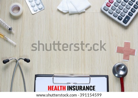 Top view of Health Insurance policy with stethoscope, hypodermic syringe, plaster, gauze, medicine, tape and calculator