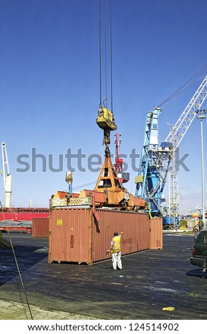 loading a container with a crane on board a ship