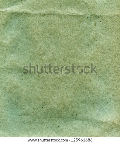 Textured grainy recycled green paper with natural fiber parts