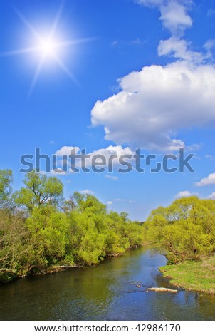 Spring sunny landscape with blue sky,river and trees