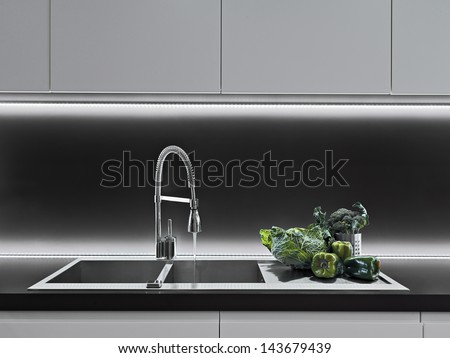 vegetables on the worktop near to sink in a modern kitchen vegetables on the worktop near to sink in a modern kitchen