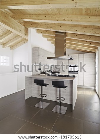 kitchen island in a modern wood kitchen with wood ceiling and tile floor