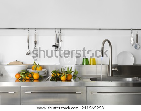 fresh orange on the worktop near to sink in a modern kitchen