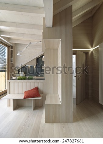 interior view of entrance and kitchen in the rustic apartment in the attic room with wood floor, wood ceiling and wooden paneling