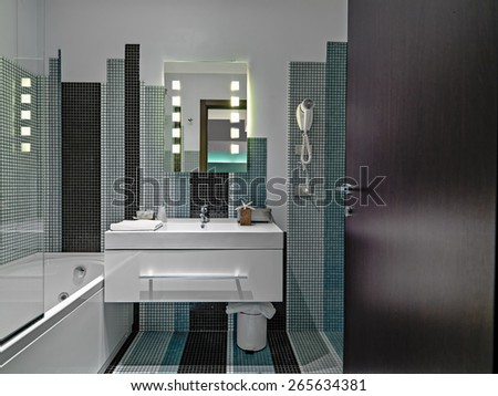interior view of a modern barthroom in the hotel with mosaic tiles in foreground the washbasin