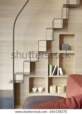 detail of iron staircase with bookcase in the living room with wood paneling