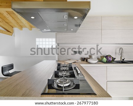 interior view of a modern wood kitchen in foreground the cooker