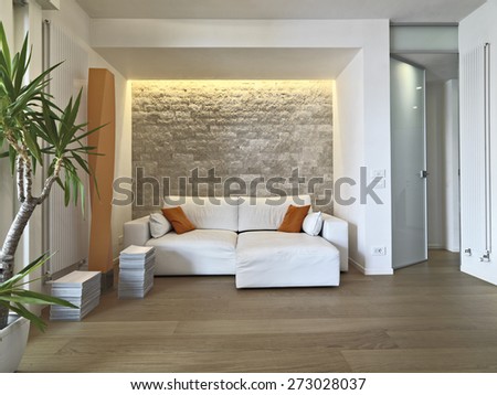 interior view of modern living room in foreground the leather sofa with orange pillow and wood floor