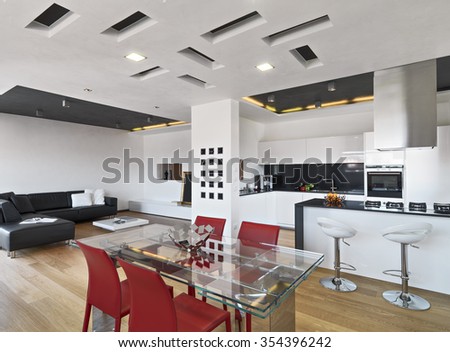 interior view of apartment with wood floor in foreground the glass dining table overlooking on the modern kitchen and on living room with leather sofa