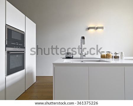 interior view of a modern kitchen with kitchen island, sink and oven the floor is made of wood