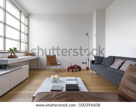 interior view of a modern living room with wooden floor a fabric sofa and toys