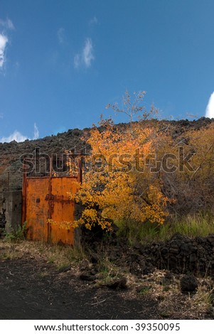 old gate in Etna volcano during autumn with lava stone background