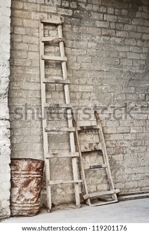 grunge wall, ladder, old barrel, vintage wheelbarrow for carrying  bags of grain background