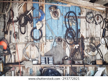 old tools hanging on wooden wall in a tool shed