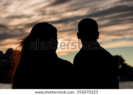 Silhouettes of young people in the beautiful sunset, the outlines of the figures. People look forward to . The faces of the people do not see.The dramatic atmosphere.The limited focus area. Blur frame