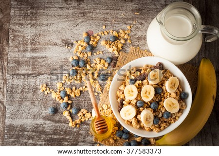 Healthy breakfast concept with oat flakes and fresh berries on rustic background. Food made of granola and musli. Healthy banana smoothie with blackberries, honey and milk.