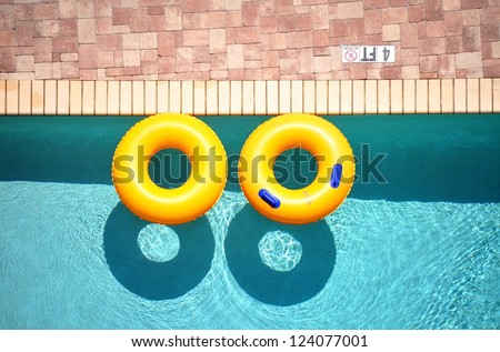 Yellow pool float, pool ring in cool blue refreshing blue pool