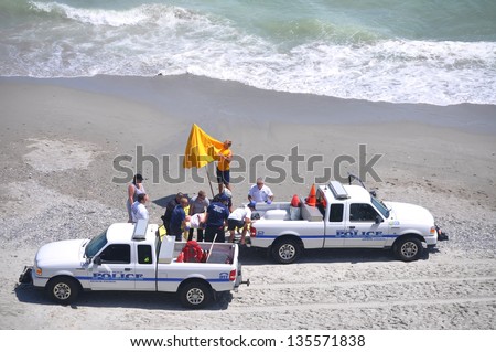 MYRTLE BEACH, SOUTH CAROLINA - APRIL 18 - Paramedics, Beach Police, Lifeguard work together to load unidentified drowning victim for transport to hospital at Myrtle Beach on the 18th of April 2013.