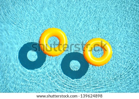 Yellow pool float, pool ring in cool blue refreshing blue pool,
