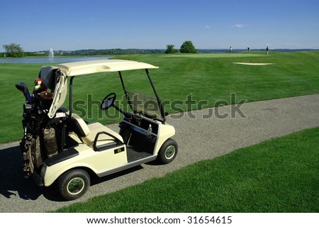 Golf cart on golf path, green in background