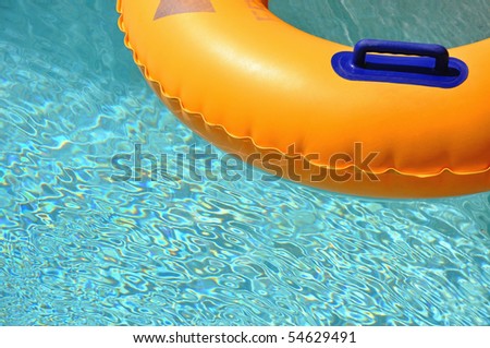Yellow pool float/ring in pretty blue swimming pool