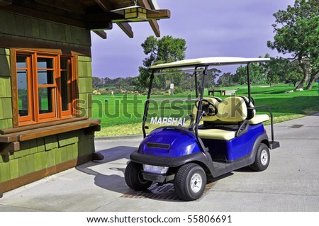 Golf cart with starter booth and golf course in background