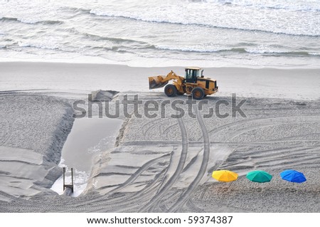 an excavator truck works on the beach