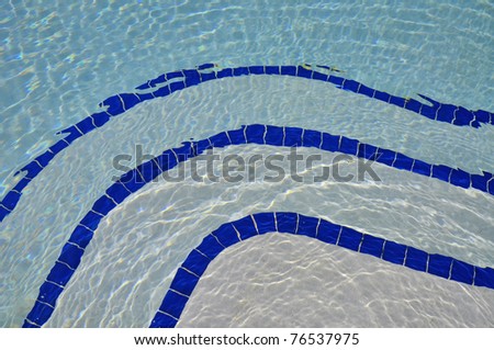 Pretty blue pool water with blue tile useful as a background pattern