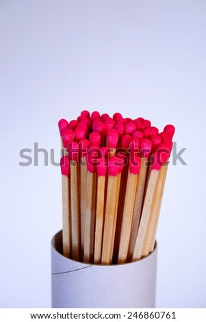 Vertical composition of a cylinder match box, red matches against white