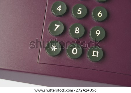 Keypad of an office phone, in violet color sort of 1990s retro, closeup