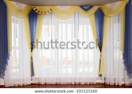 the windows decorated with curtains with a machine embroidery