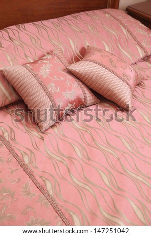 decorative pillows with an ornament on a bed about a bed back