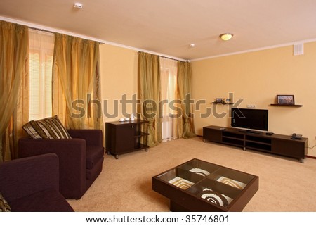 Beautiful modern hall with a sofa, an armchair, and a small little table in the room centre