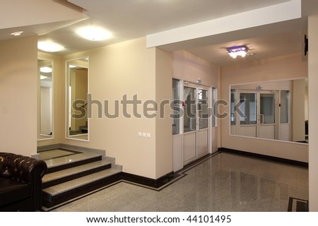 Spacious lobby with a ladder, mirrors and a sofa