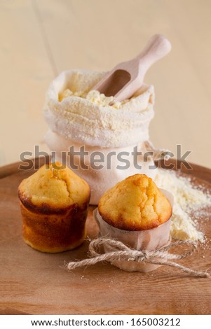 Corn muffins and a bag of flour on the round board