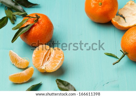 Skinless and fresh tangerines on a turquoise kitchen table (horizontal shot)