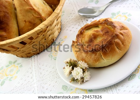 Appetizing pie and basket of meat pie in the embroider tablecloth