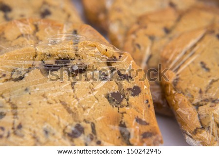 Homemade chocolate chip cookies wrapped in plastic wrap looking yummy with a shallow depth of field.