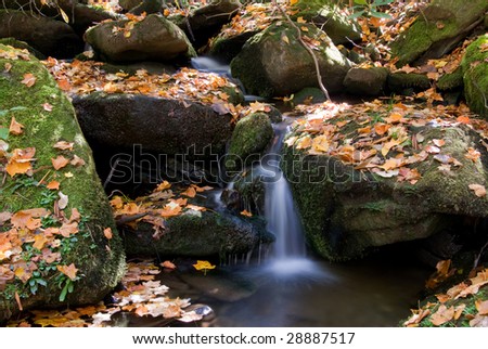 waterfall in creek with slow shutter speed during autumn