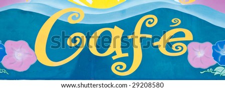 Cafe sign in blue and yellow with flowers on the sides