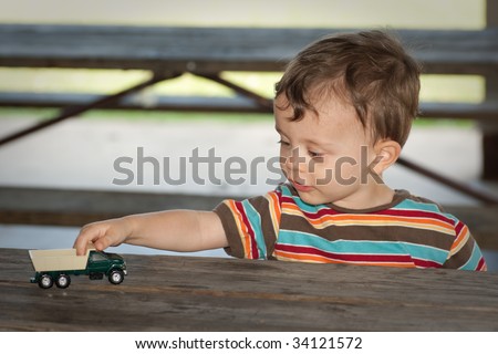 Little boy playing with toy truck