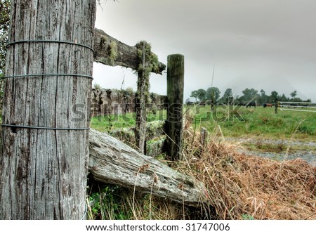 A broken wooden fence on farmland