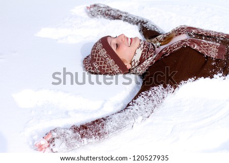 Happy girl lying on the snow
