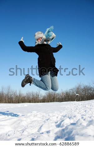 Happy jumping woman in the snowy forest