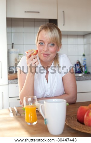 young blond woman with apples and juice/young blond woman with apples and juice at a breakfast table