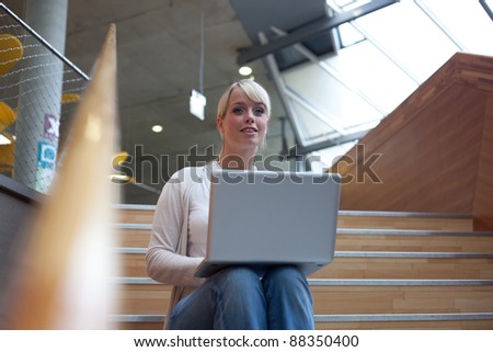 young blond woman with a laptop on the stairs/ woman with laptop