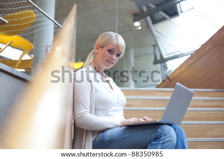 young blond woman with a laptop on the stairs/woman with a laptop