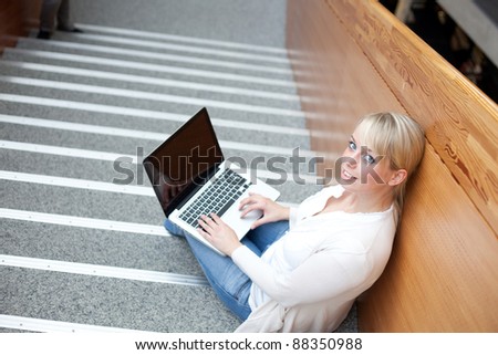 young blond woman with a laptop on the stairs/woman with a laptop